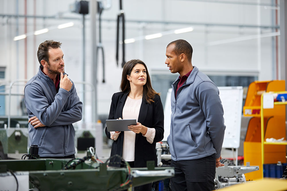 Three people speaking in an industrial environment