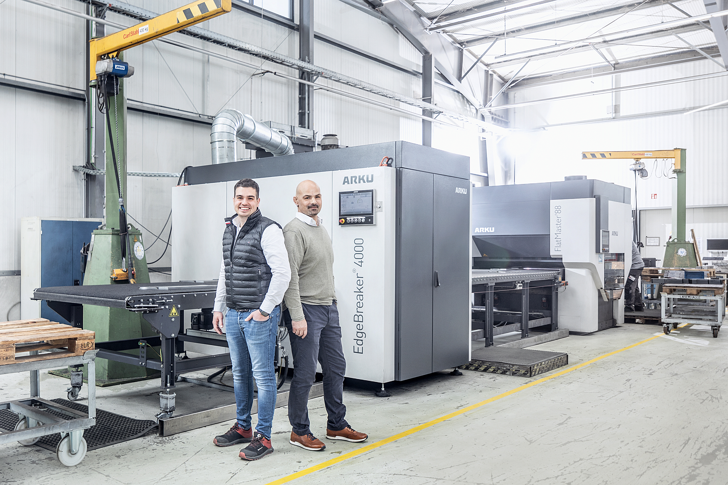 L-R: Julian Feldmeier, Department Manager, HALLER Metall, and Markus Heinrich, Technical Operations Manager, HALLER Metall, in front of their ARKU deburring and levelling machines.